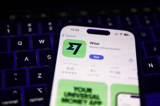 CFPB-fines-fintech-Wise-alleging-it-charged-deceptive-fees.jpg A laptop keyboard and Wise on App Store displayed on a phone screen.