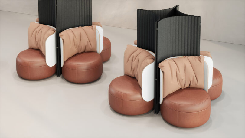 Two sets of brown cushioned seats with tan pillows are separated by tall, curved black dividers on a light gray floor