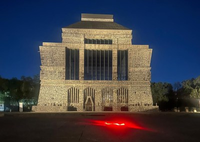 A red light is projected in front of the Museo Anahuacalli, a museum built like a mausoleum.