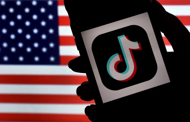 1739856064_What-to-know-about-TikToks-uncertain-future-in-the-US.jpg In this photo illustration, the social media application logo, TikTok is displayed on the screen of an iPhone on an American flag background on August 3, 2020 in Arlington, Virginia. - The US Senate voted on August 6, 2020, to bar TikTok from being downloaded onto US government employees' telephones, intensifying US scrutiny of the popular Chinese-owned video app. The bill passed by the Republican controlled Senate now goes to the House of Representatives, led by Democrats. (Photo by Olivier DOULIERY / AFP) (Photo by OLIVIER DOULIERY/AFP via Getty Images)