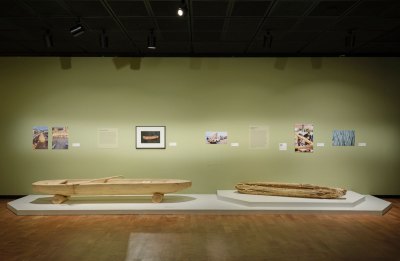 View of a museum exhibition showing two different canoes. 