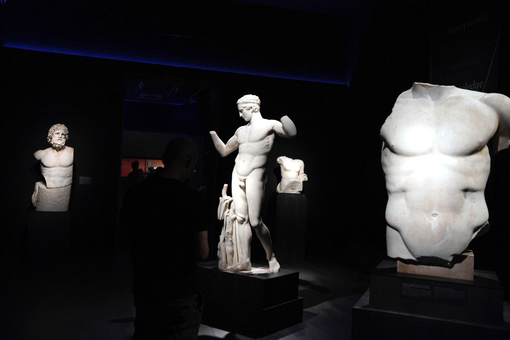 Marble statues are displayed at the new temporary exhibition «The countless aspects of Beauty» on May 27, 2018 at the National Archaeological Museum in Athens. - The exhibition, which opened for public this weekend features 340  antiquities  from the collections of the National Archaeological Museum  combined with digital applications and a perfume called "Aphrodite's rose", made by the Korres brand of Greek natural cosmetics inspired by the fragrances worn in antiquity. (Photo by LOUISA GOULIAMAKI / AFP)        (Photo credit should read LOUISA GOULIAMAKI/AFP via Getty Images)