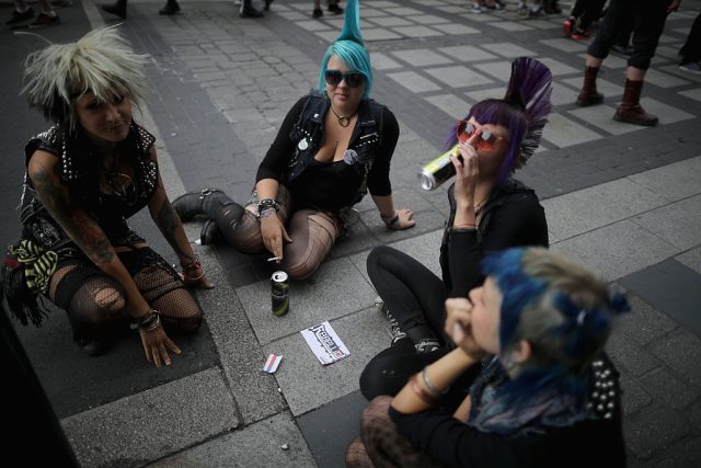 A group of punks smoking cigarettes and drinking beers.