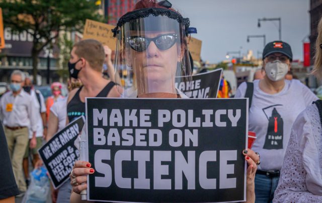 Can-public-trust-in-science-survive-a-second-battering.jpg protestor holding up sign