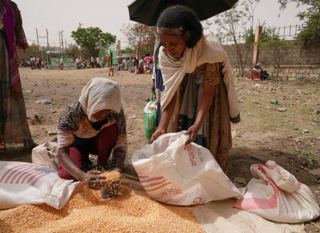 MEKELE, ETHIOPIA - JUNE 16: An aid worker distributes measured portions of yellow lentils to residents of Geha subcity at an aid operation run by USAID, Catholic Relief Services and the Relief Society of Tigray on June 16, 2021 in Mekele, Ethiopia. The distribution center at Geha is currently distributing aid to over 5,000 beneficiaries a day, a number that far exceeds its annual daily distribution numbers during the yearly drought conditions that affect the region.  The numbers have increased due to the 7 month armed conflict and the recent destruction due to the locust infestation in 2020.  G7 leaders recently called for unimpeded access for aid workers in the region where government forces and Eritrean troops have fought regional rebels starting last November. The UN has 350,000 people here are living in famine conditions, a characterization the Ethiopian government disputes, although they have admitted to "food insecurity" in Tigray. (Photo by Jemal Countess/Getty Images)