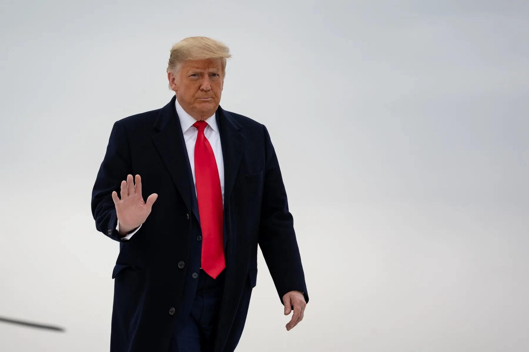 How-Will-the-Trump-Administration-Impact-Travel.jpeg An elderly man with a red tie waves