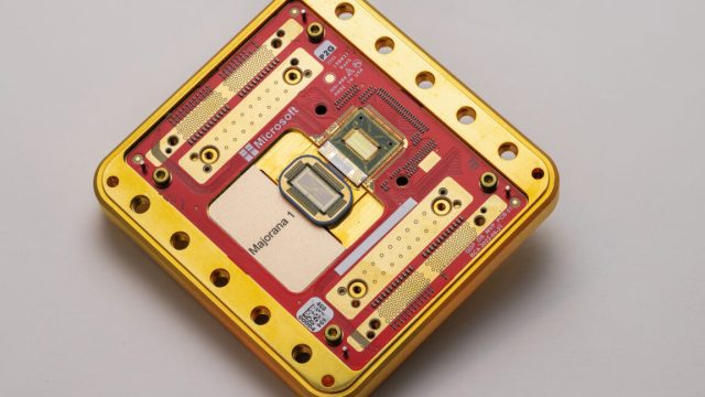 Microsoft-demonstrates-working-qubits-based-on-exotic-physics.jpg Image of a processor and its packaging, which is rectangular and primarily red and gold.