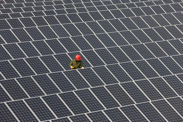 Microsoft-powers-AI-ambitions-with-400-MW-solar-purchase.jpg Man inspecting solar panels.