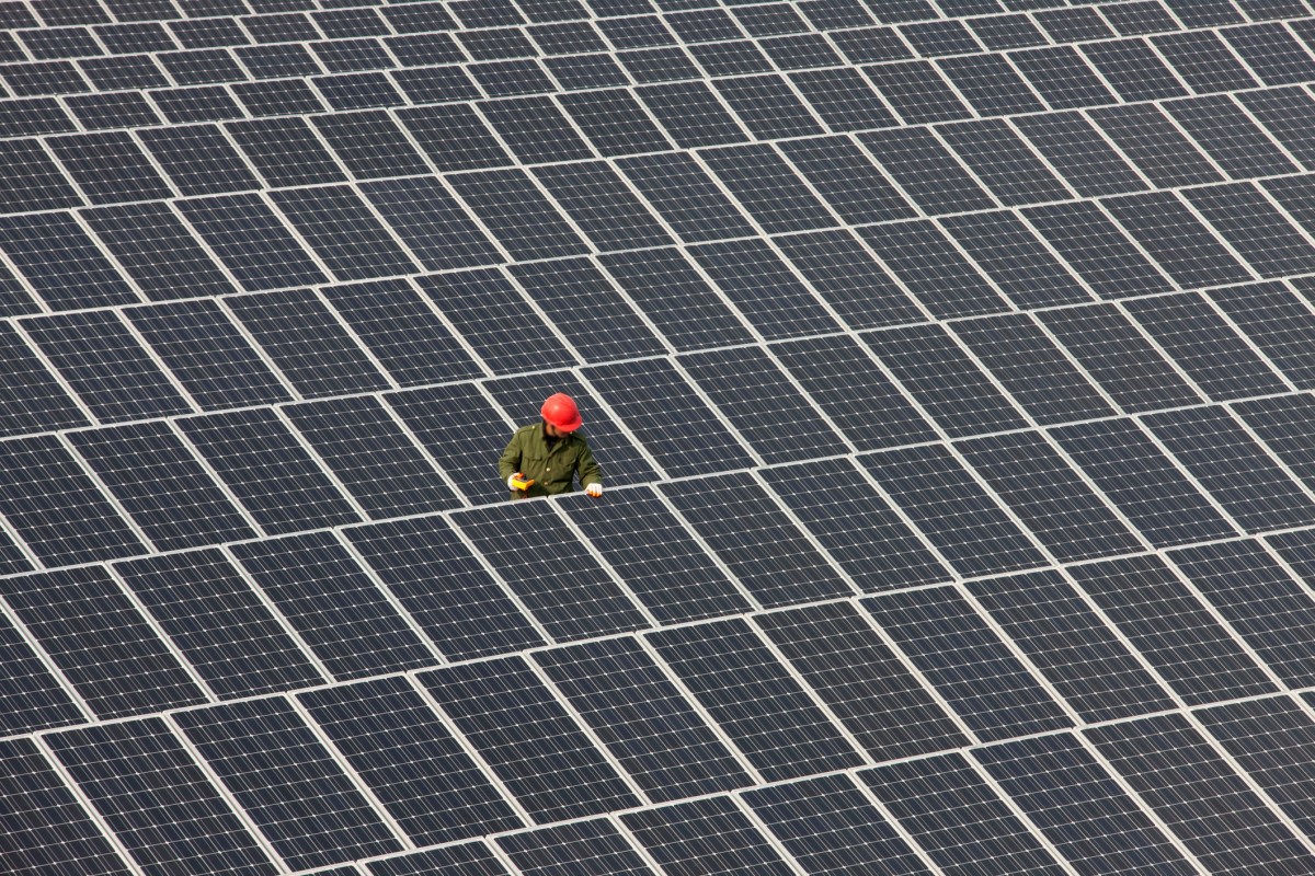 Microsoft-powers-AI-ambitions-with-400-MW-solar-purchase.jpg Man inspecting solar panels.
