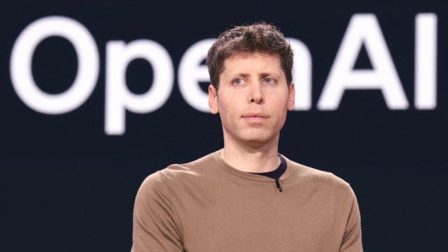 OpenAI-board-considers-special-voting-powers-to-prevent-Elon-Musk.jpg OpenAI CEO Sam Altman standing in front of a backup with a large OpenAI logo.