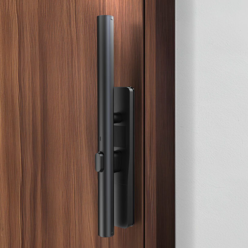Modern electronic door lock with a sleek black design installed on a wooden door.