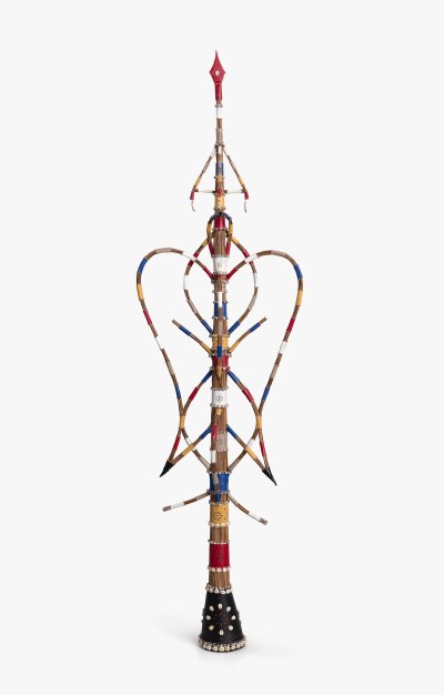A sculpture resembling a multicolored staff with various hanging elements.