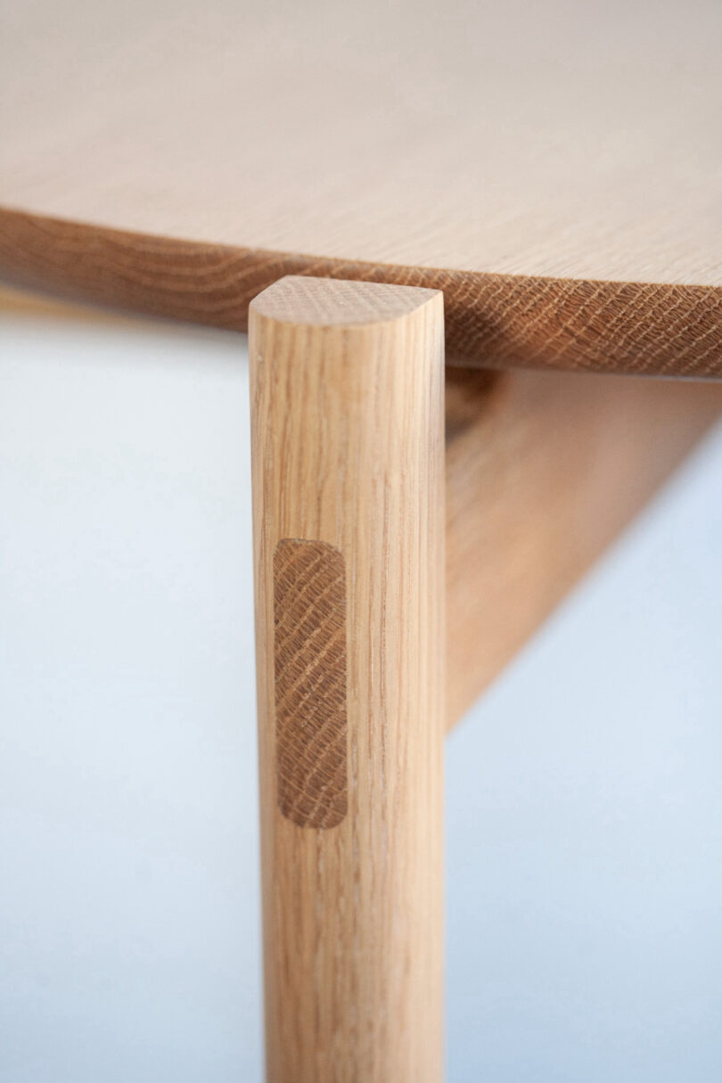 Close-up of a wooden table corner with smooth, rounded edges and a natural wood finish