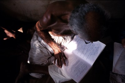 A man hunched over an open book.