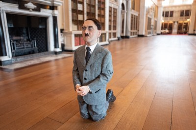 A sculpture of a kneeling Adolf Hitler.