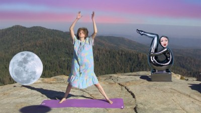 A woman on a yoga mat on a cliff beside a floating moon and a shimmering person bending over.