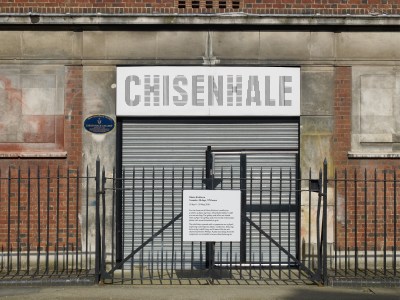 A sign reading 'CHISENHALE' above a closed gate with another sign attached to it.
