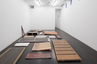 A group of ramps, some ready-made and some makeshift, shown on a gallery floor.