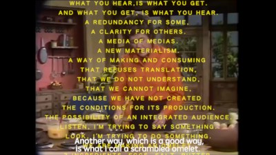 A grainy image of a woman cooking an omelet with open captions reading 'Another way, which is a good way, is what I call a scrambled omelet.' More text is overlaid over all this that begins 'WHAT YOU HEAR IS WHAT YOU GET.'