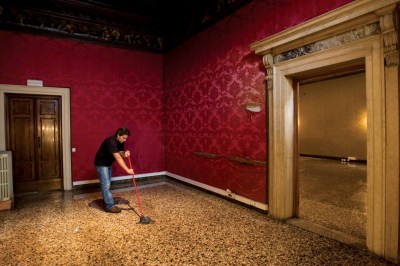 A person mopping the floor of an empty room.