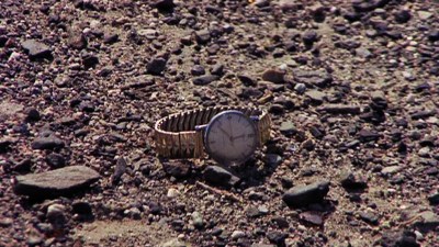 A watch lying in gravel.