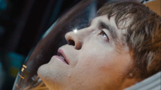1741563665_Review-Mickey-17s-dark-comedic-antics-make-for-wild-cinematic.jpg closeup shot of a man in a spacesuit staring out into inky blackness