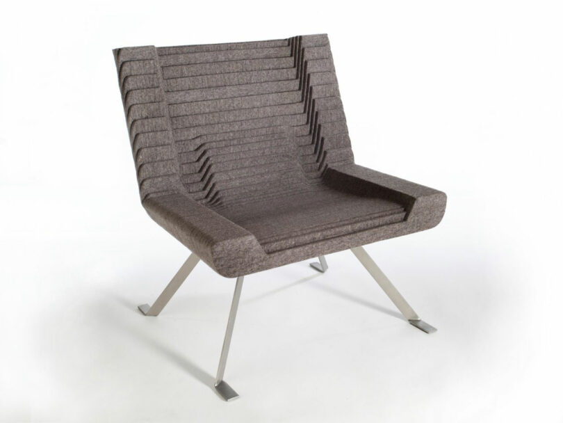 Modern gray chair with a geometric design, featuring a series of horizontal padded layers and four angled metal legs.