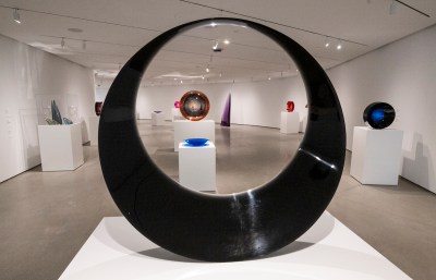 A group of semi-transparent discs on pedestals in a gallery.