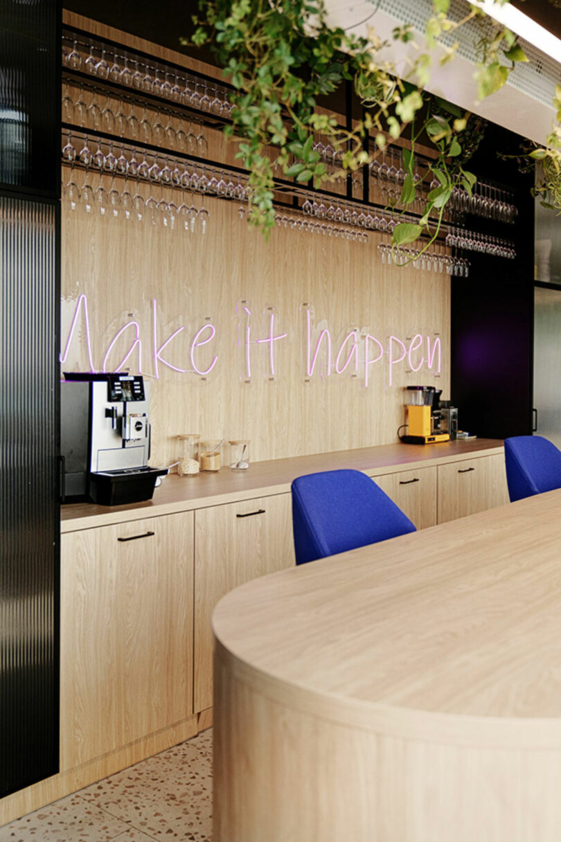 Office kitchen area with wooden cabinets, coffee machines, and a 