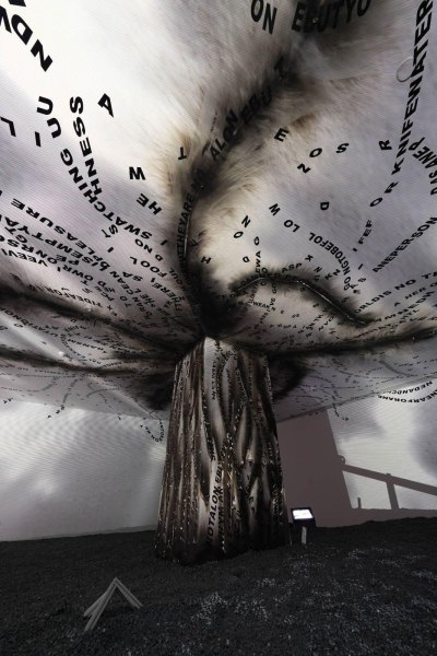 An installation that appears to be a tornado of words is on view in a gallery.