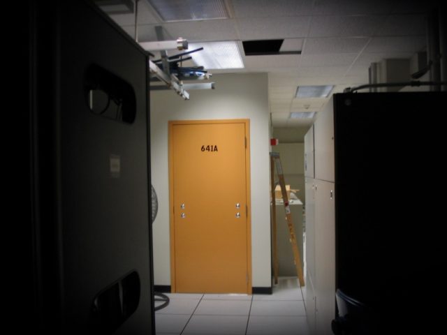ATT-technician-Mark-Klein-who-exposed-secret-NSA-spying-dies.jpg a photo of the exterior of Room 641A, which has a yellow door without a door handle, in a dimly lit datacenter in a San Francisco AT&T hub.