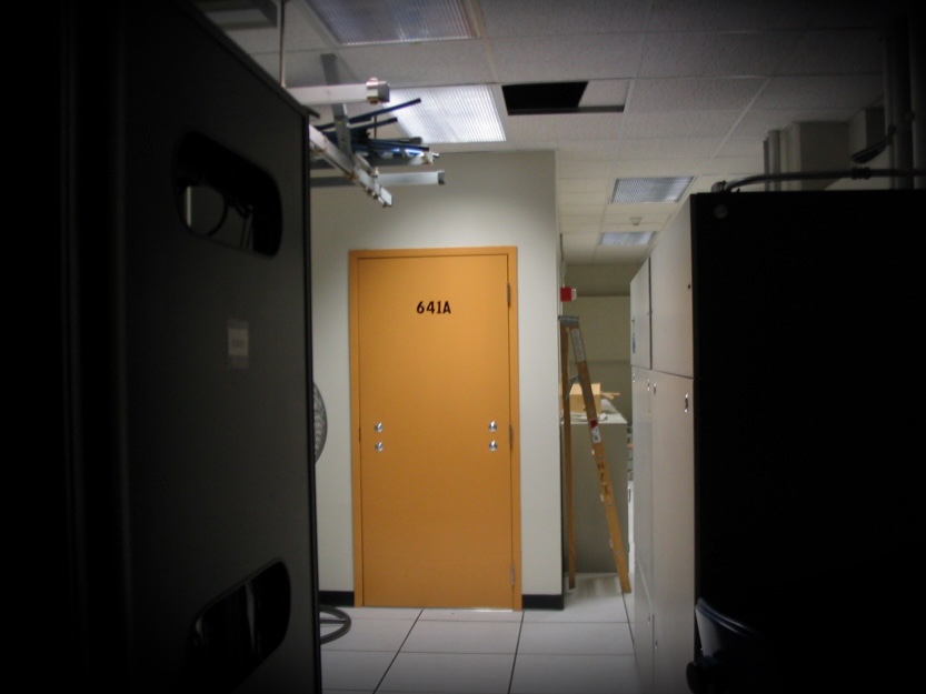 ATT-technician-Mark-Klein-who-exposed-secret-NSA-spying-dies.jpg a photo of the exterior of Room 641A, which has a yellow door without a door handle, in a dimly lit datacenter in a San Francisco AT&T hub.