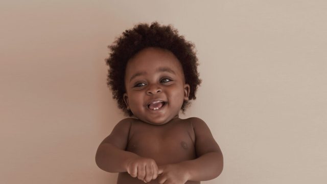 Infantile-amnesia-occurs-despite-babies-showing-memory-activity.jpg Image of a young child, showing from the waist up, against a beige background.