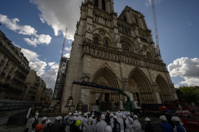 Notre-Dame-Raffles-Stones-to-Support-Religious-Heritage-in-France.jpg A large stone cathedral against a blue sky with clouds.