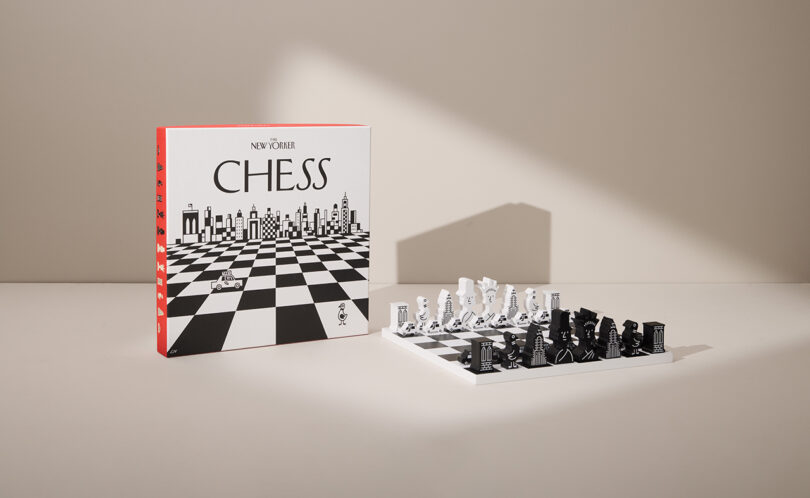 Chess set with black and white pieces arranged on a chessboard. A box labeled 