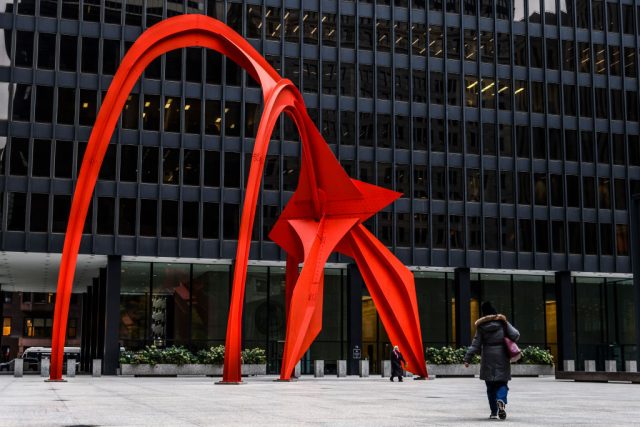 Trump-Moves-to-Fire-Caretakers-of-Federal-Art-Collections.jpg An arcing red statue in a plaza.