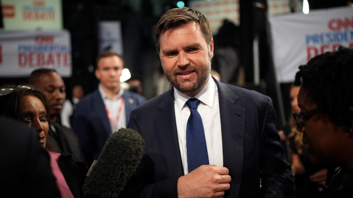 Trump-administration-accidentally-texted-secret-bombing-plans-to-a-reporter.jpg JD Vance speaks to reporters while a large microphone is held near his head.
