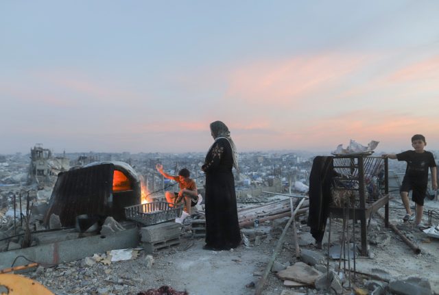 What-the-faltering-ceasefires-in-Gaza-and-Ukraine-reveal-about.jpeg A Palestinian family cooks food on the roof of a partially demolished building in Beit Lahia, Gaza Strip, on March 17, 2025.