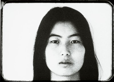Film still of an Asian woman staring at the camera. 