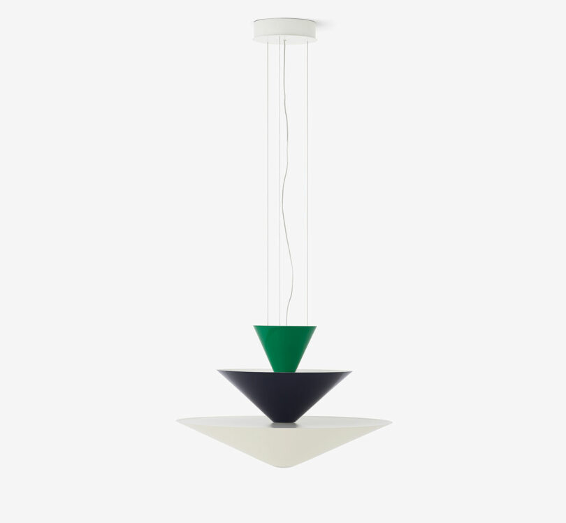 A geometric pendant light fixture featuring stacked cones in green, black, and white, suspended from a white ceiling mount.