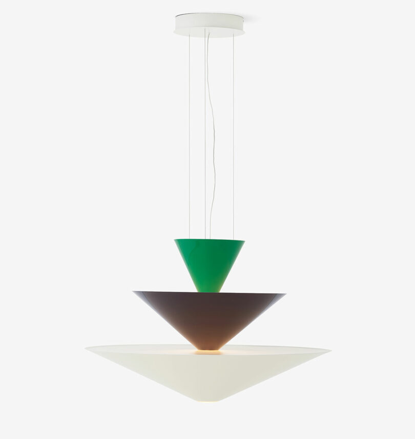 A pendant light fixture with three stacked conical shades in green, brown, and white, suspended by cables.