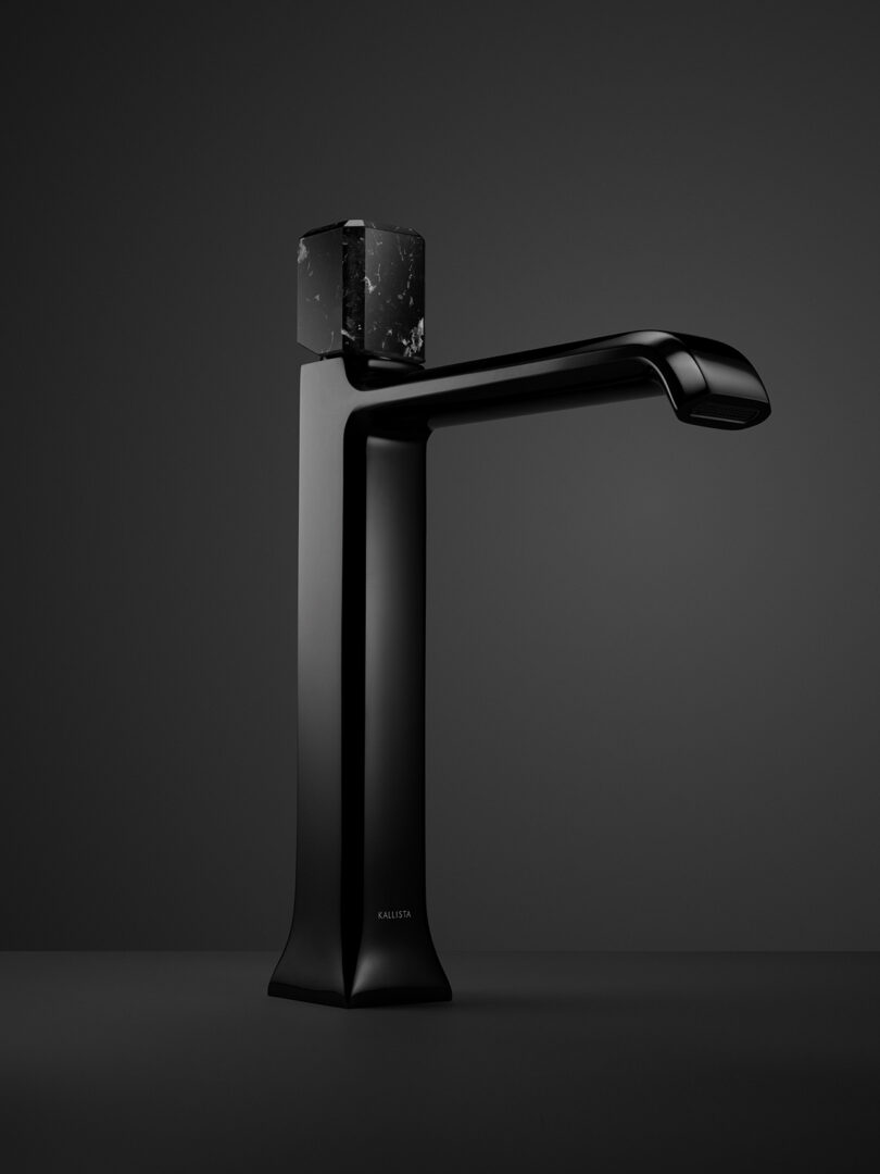 A sleek, modern black faucet with a geometric design on a dark background.
