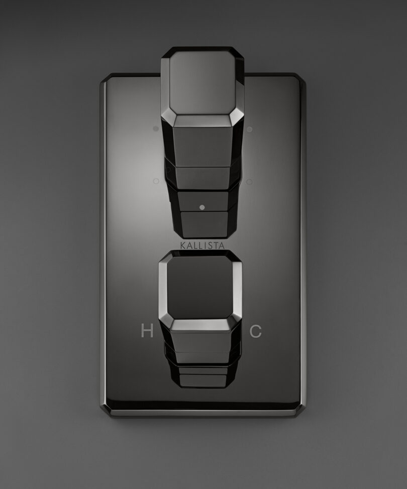 Black geometric shower controls with hexagonal handles on a dark background, marked with 
