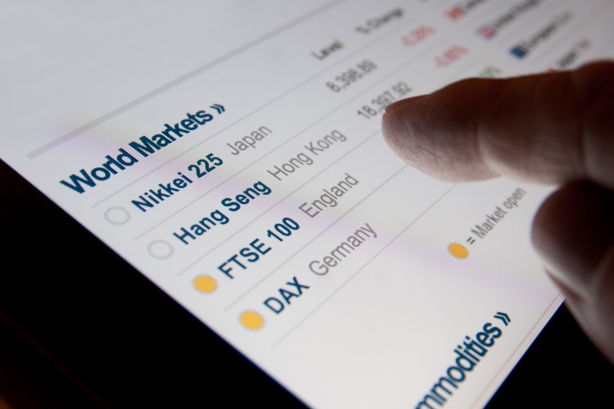 1744978085_Which-Travel-Stocks-are-Sinking-Most-on-Monday.jpeg A finger hovering over a screen listing world markets.