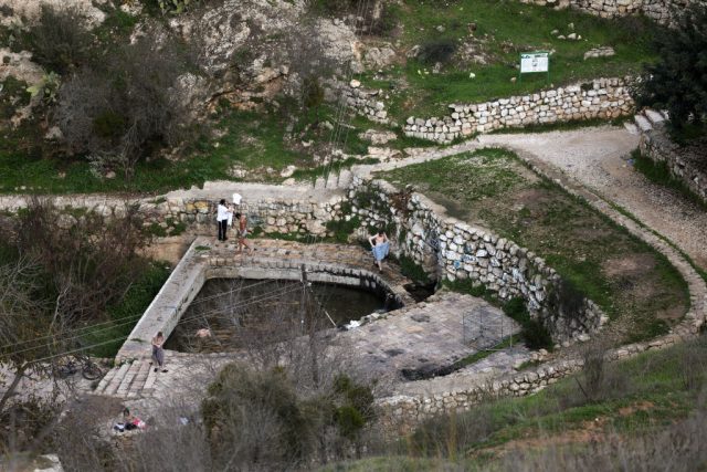 This picture shows a natural pool of water in the centre of the Palestinian village of Lifta, which was abandoned during fighting in the 1948 Arab-Israeli war, on the outskirts of Jerusalem, on December 30, 2022. Lifta, a rare example of a still existing abandoned Palestinian village, lies in a bucolic spot at the entrance to Jerusalem, and is at the centre of a preservation fight over an Israeli plan to build villas there.The village, in mainly Jewish west Jerusalem, is on a tentative list of UNESCO World Heritage sites. The World Monuments Fund organisation has put it on its list of sites under threat. (Photo by AHMAD GHARABLI / AFP) (Photo by AHMAD GHARABLI/AFP via Getty Images)