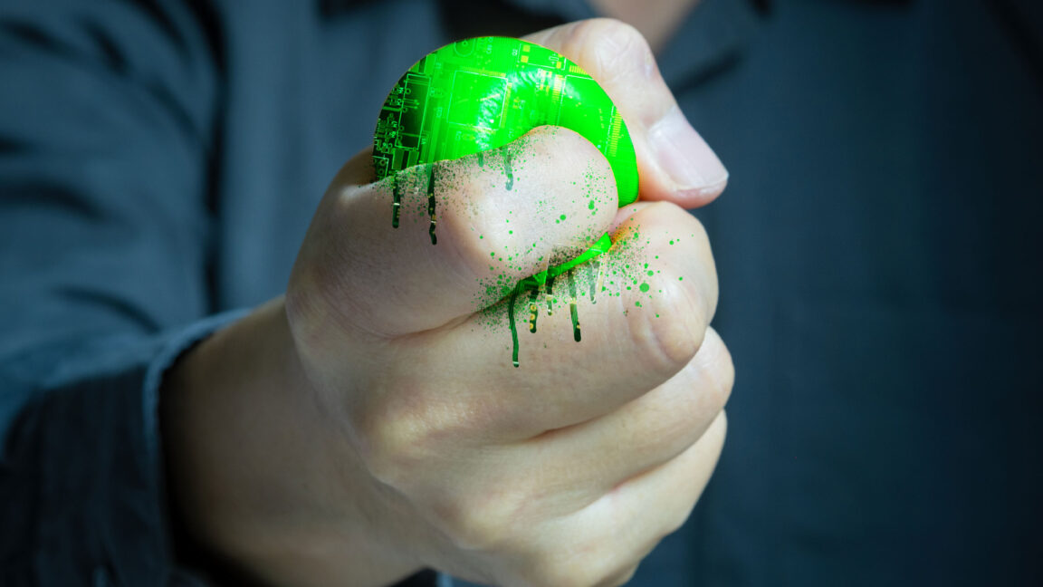 Not-just-Switch-2-ESA-warns-Trumps-tariffs-will-hurt.jpg A fist squeezing electronics until they ooze out between its fingers