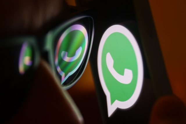 WhatsApps-latest-feature-makes-your-messages-even-more-private.jpg WhatsApp logo reflected on sunglasses and displayed on a phone screen.