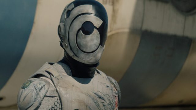 1747743844_The-making-of-Apple-TVs-Murderbot.jpg shot of head and upper torso of white armored robot and a faceless mask