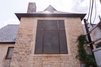 View of a rusted window on the exterior of a church. 