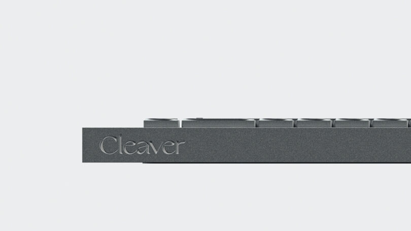 A close-up side view of the minimalist Cleaver keyboard in dark gray, with 